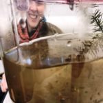 Volunteer behind a jar containing a frog egg mass